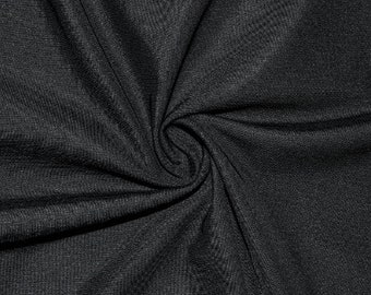 May include: Close-up of a black fabric with a textured surface. The fabric is wrinkled and folded, creating a soft, draping effect.