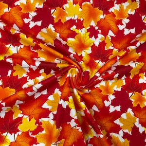 May include: Fabric with a repeating pattern of autumn maple leaves in shades of red, orange, and yellow against a white background. The fabric is likely cotton or a similar material, suitable for quilting or apparel.