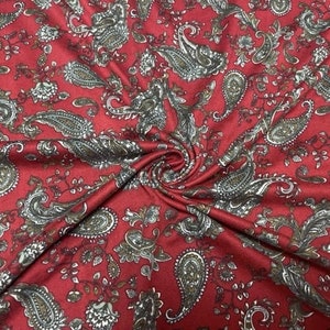 May include: Red fabric with a paisley pattern in shades of brown and gray.