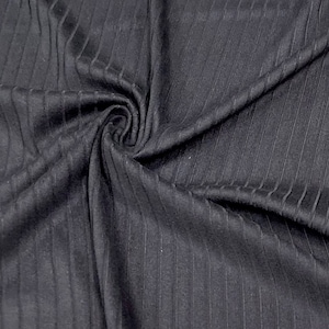 May include: Black ribbed fabric with a vertical texture. The fabric is folded and draped, showing the texture and drape of the material.