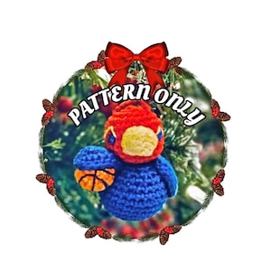 May include: Crochet pattern for a basketball-themed Christmas ornament. The ornament is a blue bird with a red head and a basketball in its hand. The ornament is surrounded by a wreath of pine branches and red berries.