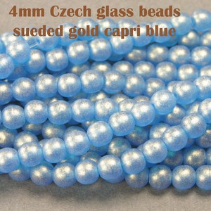 May include: A close-up of a strand of 4mm Czech glass beads in a sueded gold capri blue color. The beads are round and have a slightly textured surface.