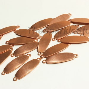 May include: Copper-colored oval connector links with small loops at each end, scattered on a white surface. The links are smooth and metallic, ideal for jewelry making or crafting projects. The image includes the text "TheSparkleStore".