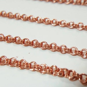 May include: Close-up of several strands of copper-colored chain. The chains are made of small, round links, creating a delicate and intricate pattern. The chains are likely used for jewelry making.