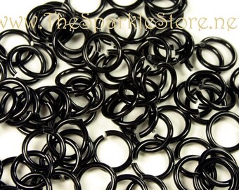 May include: A large pile of black jump rings. The rings are all the same size and are made of metal. They are used for jewelry making and other crafts.