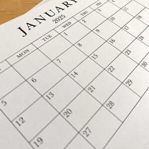 Puede incluir: Un calendario blanco con el mes de enero de 2025 impreso en &eacute;l. El calendario muestra los d&iacute;as de la semana, de lunes a s&aacute;bado, y las fechas correspondientes para cada d&iacute;a.