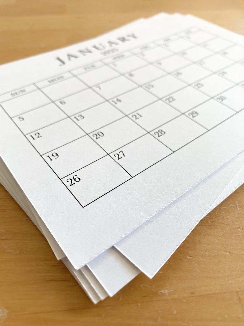 Puede incluir: Una pila de p&aacute;ginas de calendario en blanco para el mes de enero. El calendario est&aacute; impreso con el mes y el a&ntilde;o, y los d&iacute;as de la semana est&aacute;n etiquetados.