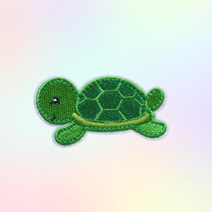 May include: A green turtle patch with a smiling face and a geometric shell design. The patch has a white border and a yellow outline on the shell. The turtle is set against a soft, pastel-colored background.