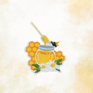 May include: Embroidered patch featuring a jar of honey with a honey dipper, a bee, and honeycomb. The jar is filled with yellow honey, and the bee is black and yellow. White daisies and green leaves are at the bottom.