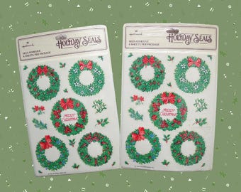 May include: Two packages of Hallmark Holiday Seals stickers. Each package contains four sheets of self-adhesive stickers. The stickers feature green wreaths with red bows and the text "Merry Christmas".