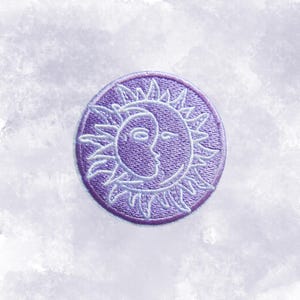 May include: A round, purple embroidered patch featuring a sun and moon design. The sun has pointed rays, and the moon has a face. The patch is a celestial-themed accessory, suitable for clothing or bags.