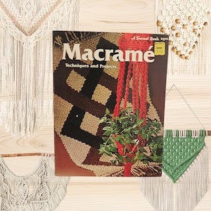 May include: A softcover instructional book titled Macramé Techniques and Projects, featuring a cover image of a red macramé plant hanger holding a green plant and a geometric wall hanging. The book includes a yellow price sticker in the corner.