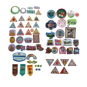 May include: A collection of colorful Girl Scout patches in various shapes and designs. The patches feature text, illustrations, and logos, including a rainbow, a zebra, and the words "Keep the Promise."