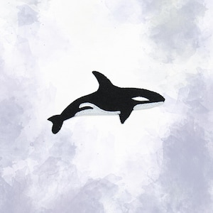 May include: A black and white orca patch with a white border. The patch features a detailed design of the killer whale, with its distinctive markings. The patch is likely for clothing or accessories.
