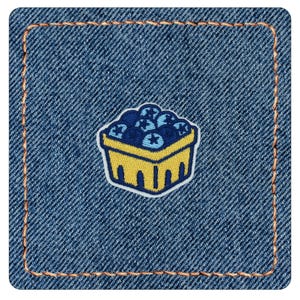 May include: A square denim patch with rounded corners and copper-colored stitching around the border. Centered on the blue fabric is an embroidered patch depicting a yellow basket filled with round, dark blue blueberries.