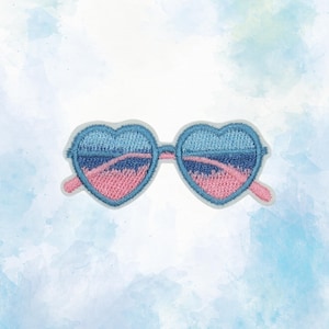 May include: An embroidered patch shaped like heart-style sunglasses. The lenses feature a gradient design with light blue at the top, transitioning into dark blue and pink horizontal bands. The frame is outlined in a light blue thread.
