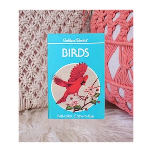 May include: A vintage "Golden Books" book titled "BIRDS" with a bright blue cover. The cover features a red cardinal illustration perched on a flowering branch. The text "Full-color, Easy-to-Use" is printed at the bottom.