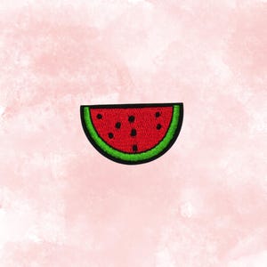 May include: Embroidered watermelon patch featuring a red interior with black seeds, a green rind, and a black border. The patch is in the shape of a watermelon slice. The background is a watercolor wash of pink.