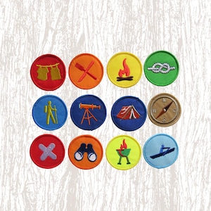 May include: A collection of twelve colorful embroidered patches with camping and outdoor activity designs. Each patch is round with a different image, including a campfire, tent, compass, and binoculars. The patches are on a textured, off-white background.