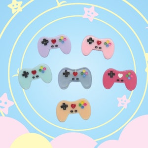 May include: Six colorful plastic game controllers with a heart and colorful buttons. The controllers are in shades of pink, blue, light blue, and peach.