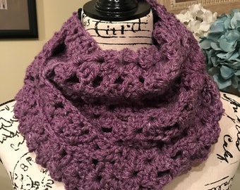 May include: A purple crocheted infinity scarf with a delicate openwork pattern.