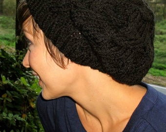 May include: A black knitted beanie with a textured pattern. The beanie is worn by a person with dark hair and a blue shirt.