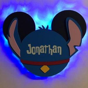 May include: Blue and pink Stitch-themed night light with a blue glow and the name "Jonathan" written on it.