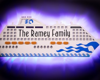 May include: White cruise ship cutout with the text "The Ramey Family" on the side. The ship has blue and white waves and orange life rafts.
