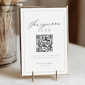 May include: A gold-framed sign with the words "Honeymoon Fund" in elegant script. Below is a QR code and text that reads "Thank you for celebrating our special day with us" and the names "Pia & Henry".