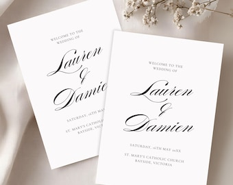 Puede incluir: Dos tarjetas de bienvenida de boda blancas con elegante escritura negra. Las tarjetas dicen "Bienvenida a la boda de Lauren & Jamie" e incluyen la fecha y el lugar. Delicadas flores blancas en el fondo.