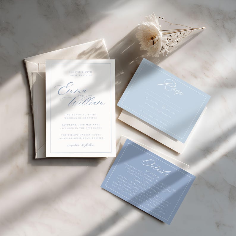 May include: Elegant wedding invitation suite featuring a main invitation, RSVP card, and details card. The invitation is white with a light blue border and script text that reads "Emma and William". The RSVP and details cards are light blue with white text. A white envelope is also included.