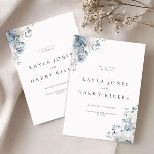 May include: Two white wedding invitation cards with floral accents in shades of blue and white. The cards feature the names "KAYLA JONES AND HARRY RIVERS" and wedding details. The text "welcome to the wedding of" is at the top.