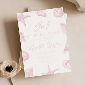 May include: A light pink bridal shower invitation with seashell and starfish illustrations. The invitation reads "She'll Be Here Soon" and includes event details for Elizabeth Clayton.