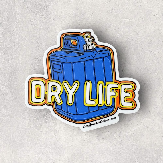 “Dry Life” Vinyl Sticker (5x5):
Alaska: Home of the “Dry Cabin” life, where living without running water means hauling in every drop. For five years, I embraced this rugged lifestyle, relying on those iconic blue jugs to keep life flowing. Inspired by those roots, I created the Dry Life sticker – a 4x4 design perfect for your car, truck, or even your trusty blue jug. Waterproof, weatherproof, and durable, it’s a tribute to resilience and adventure.