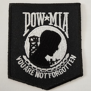 May include: Black and white embroidered patch with the text "POW*MIA YOU ARE NOT FORGOTTEN" and a silhouette of a soldier's head inside a circle.