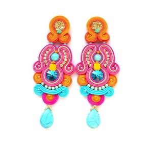 May include: A pair of colorful dangle earrings with turquoise, pink, orange, and gold accents. The earrings feature a teardrop-shaped turquoise stone at the bottom.