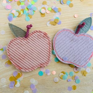 Könnte beinhalten: Eine weiße Keramiktasse mit schwarzem Henkel und dem Text "But first, coffee" in schwarzer, handschriftlicher Schrift. Die Tasse steht auf einer weißen Oberfläche.