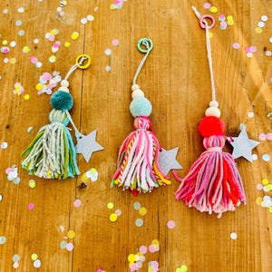 Könnte beinhalten: Eine weiße Keramik-Tasse mit schwarzem Henkel und dem Text "But First, Coffee" in fetter, schwarzer Schrift. Die Tasse steht vor einem verschwommenen Hintergrund, der eine gemütliche Umgebung suggeriert.