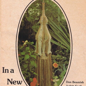Puede incluir: Portada de libro con una lámpara colgante de macramé sobre un fondo de vegetación. El título "Macramé... In a New Light" se muestra en negrita negra. También se ven los nombres de los autores, Don Beamish y Judith Snell.