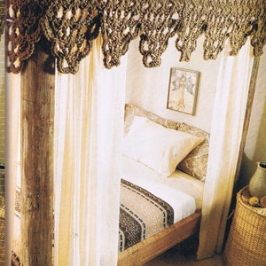 May include: A wooden bed frame with white curtains and a crocheted canopy. The bed has a white duvet and a patterned throw blanket. A small wicker basket sits on the floor next to the bed.