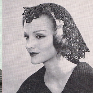 Könnte beinhalten: Ein schwarzer Häkelspitzenhut mit einem gewellten Rand. Der Hut wird von einer Frau mit kurzen, gewellten Haaren getragen. Sie trägt ein schwarzes Oberteil.