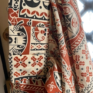 May include: Red and white patterned fabric curtains with silver clips. The fabric has a geometric design with black accents.