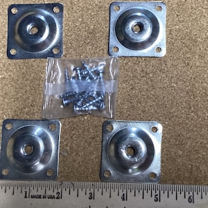 May include: Four silver metal square furniture feet with rounded edges and a screw hole in the center. A bag of silver screws is included.