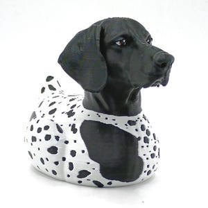 May include: A 3D-printed sculpture of a dog, featuring a black head and ears, and a body with a white base and black spots. The dog is posed looking to the right, with a smooth, textured finish.