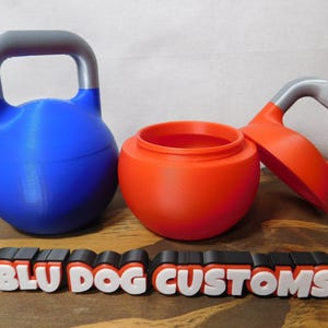 May include: Two 3D printed kettlebells, one blue with a silver handle and one red with a silver handle. The red kettlebell is open and the lid is off. The kettlebells are sitting on a wooden surface with a sign that reads "BLU DOG CUSTOMS".