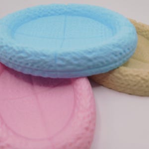 Op de afbeelding: Drie keramische kommen in verschillende kleuren: lichtblauw, roze en beige. De kommen hebben een getextureerd, geweven ontwerp rond de rand.