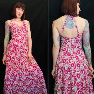 May include: A pink and white floral maxi dress with a halter neckline and a low back. The dress has a fitted bodice and a flowing skirt.