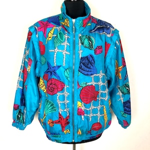 May include: A blue jacket with a colorful seashell and starfish print. The jacket has a zipper closure and a stand-up collar.