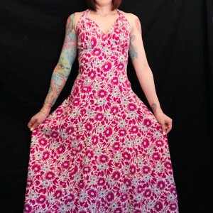 May include: A long, pink and white floral print halter dress with a V-neckline.