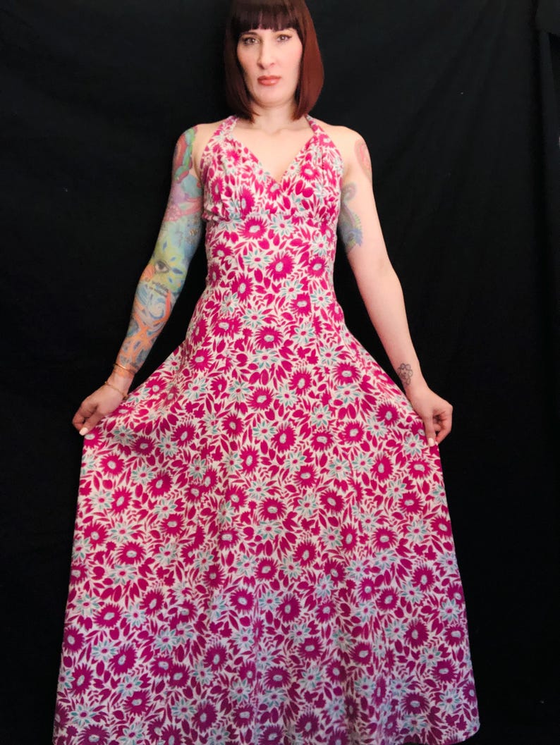 May include: A long, pink and white floral print halter dress with a V-neckline.